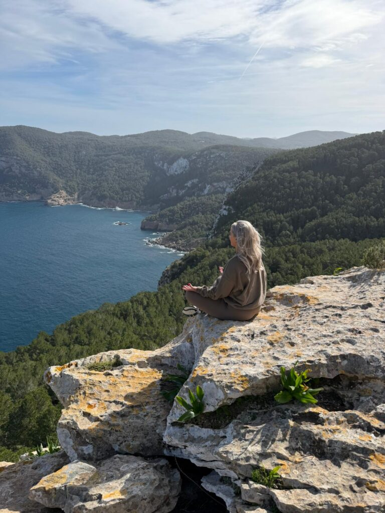 Yoga retreat voor vrouwen, Femke mediteert op rots met uitzicht op zee en bergen